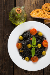 Black pasta with olives and cherry tomatoes