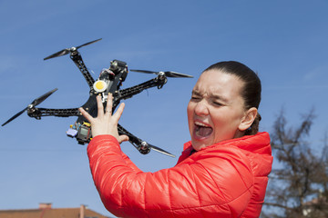 Pretty young woman screams just a moment before drone quadrocopter attack or hit, in the city, on sunny day, space for text