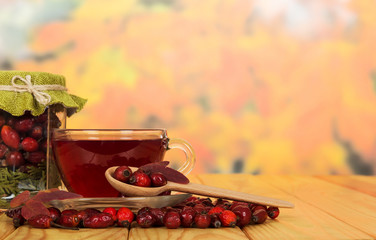 Tea, hips, a wooden spoon on the autumn background