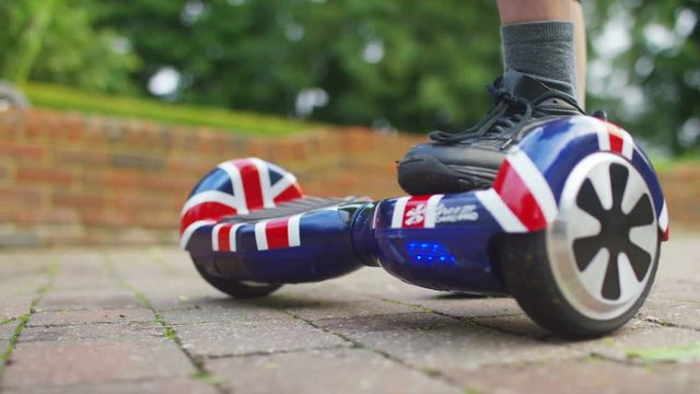  Young boy playing on motorized hover board in the garden 
