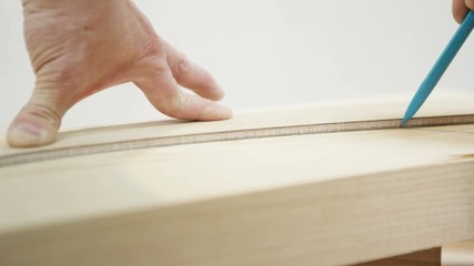  Close up on hands drawing a template on wood in a carpenter's workshop. Shot on RED Epic.