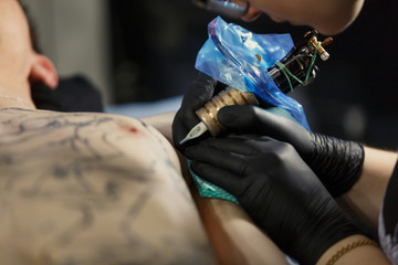 Showing process of making a tattoo by professional girl artist in studio.