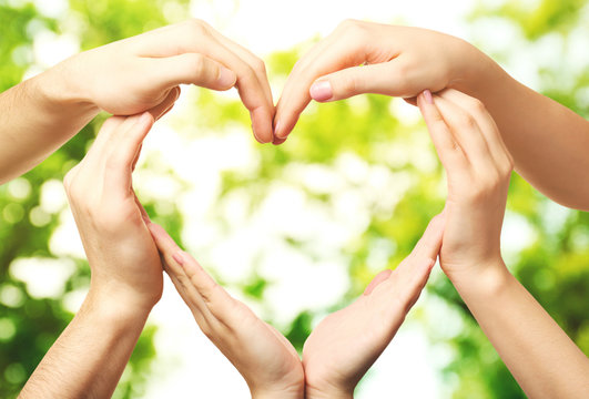 Hands in shape of heart, on blurred nature background