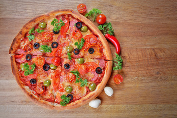 Tasty pizza with sausage and vegetables on wooden table background