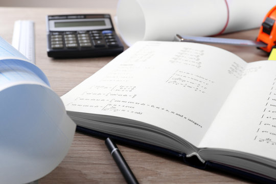 School supplies and textbook on mathematics close up