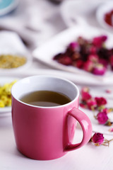 Cup of tea with aromatic dry tea on wooden background