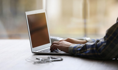 Man's hands using laptop at the table