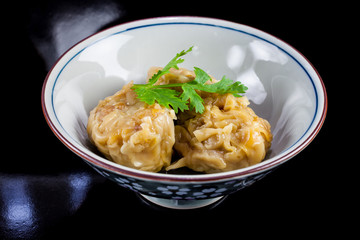 Chinese yum cha, pork dumpling Shumai in white bowl.