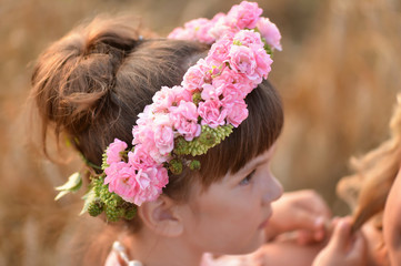 Naklejka premium a wreath of pink roses on the head of a little girl. Profile