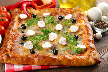Freshly homemade pizza on wooden table closeup