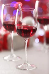 Fotobehang Wineglasses on red blurred lights background © Africa Studio