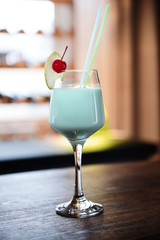 Glass of cocktail on bar background