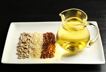 Different kinds of seeds and oil on wooden table