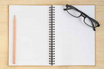 Fototapeta premium Top view of spiral notebook and pencil