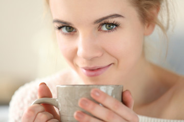 Blonde beautiful girl enjoying her cup of hot delicious coffee