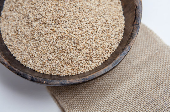 Sesame seeds in rustic wooden bowl on sackcloth