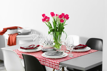 Table served with dishes and a bouquet of tulips