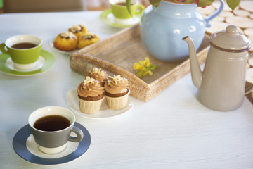 Table setting with tea and cakes indoors