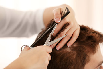 Professional hairdresser making stylish haircut, closeup