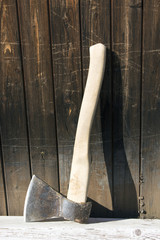 Traditional iron axe with wooden handle in wooden plank wall