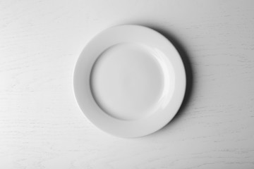 Empty plate on white wooden background