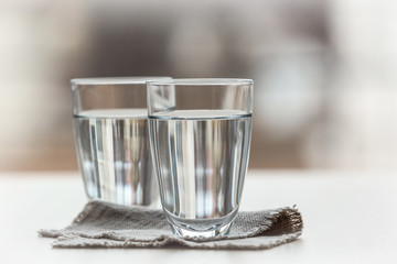 Two glasses of pure water on blurred background