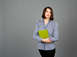 Woman in blue blouse standing and keep her green notes. Business girl in studio