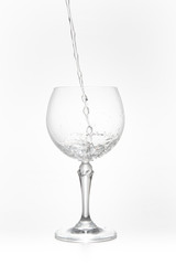 Pouring water on a glass on white background