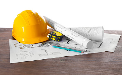 Construction blueprints with tools and helmet on white background