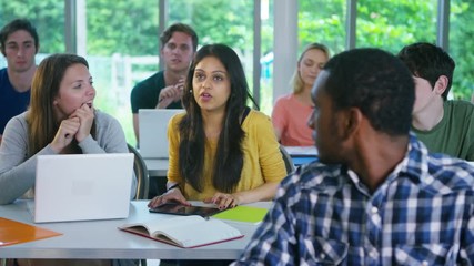  Group of students in class, listening to the teacher and asking questions