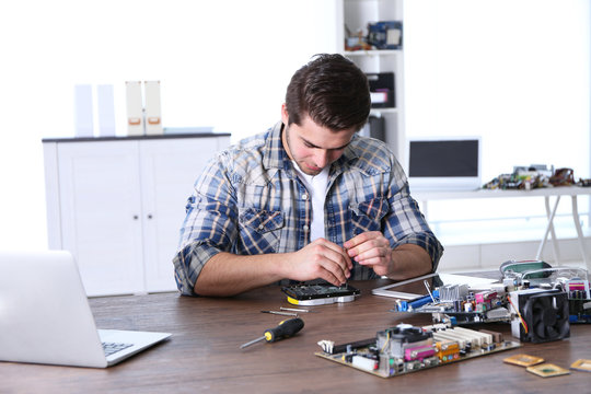 Man fixing electronic circuits in service center
