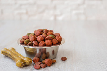 Bowl with dog food on the floor in front of brick wall background