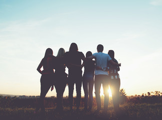 Fototapeta Group of people hugging outdoors; sunset  obraz