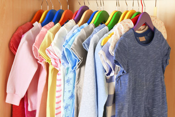 Kid's clothes on hangers in the wardrobe