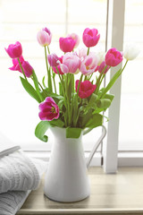 Beautiful fresh tulips on windowsill background