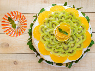 Fruit cake (orange, kiwi, mint) with a glass, close-up. top view