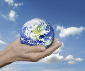 Earth in hands over blue sky with white clouds, Environment conc