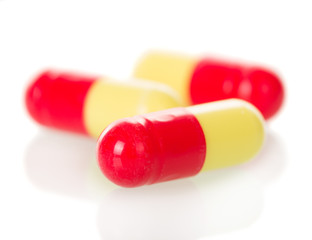 Macro. Red and yellow capsules isolated on white 