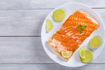 salmon fillet on a white dish, top view