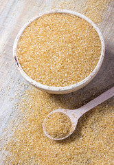 Brown sugar cane on the wooden background.