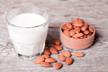 glass of almond milk and almond close