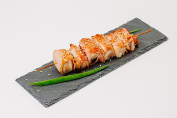 grill meat on a wooden skewer with green onions on a white background