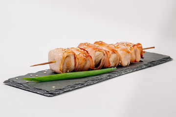 grill meat on a wooden skewer with green onions on a white background