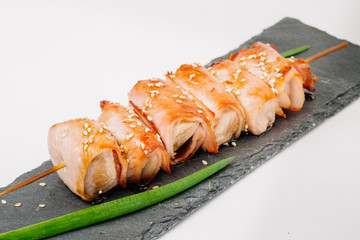 grill meat on a wooden skewer with green onions on a white background