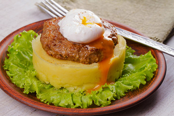Beef and pork patty with poached egg, smashed potato and lettuce