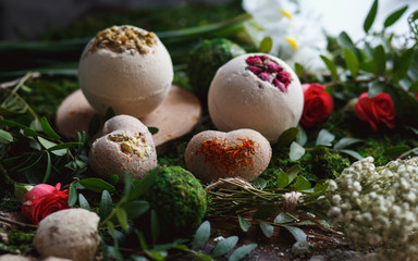 Preparation of bath bombs. Ingredients and floral decor on a wooden vintage table.