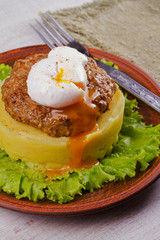 Beef and pork patty with poached egg, smashed potato and lettuce