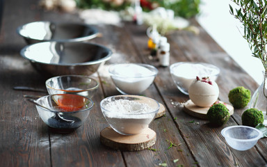 Preparation of bath bombs. Ingredients and floral decor on a wooden vintage table.