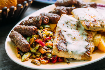 Assorted delicious grilled meat with vegetables on wooden table
