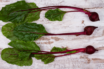 Vegetables on old  dark desk: baby carrot, garlic, beetroot, radishes. View from above, top studio shot